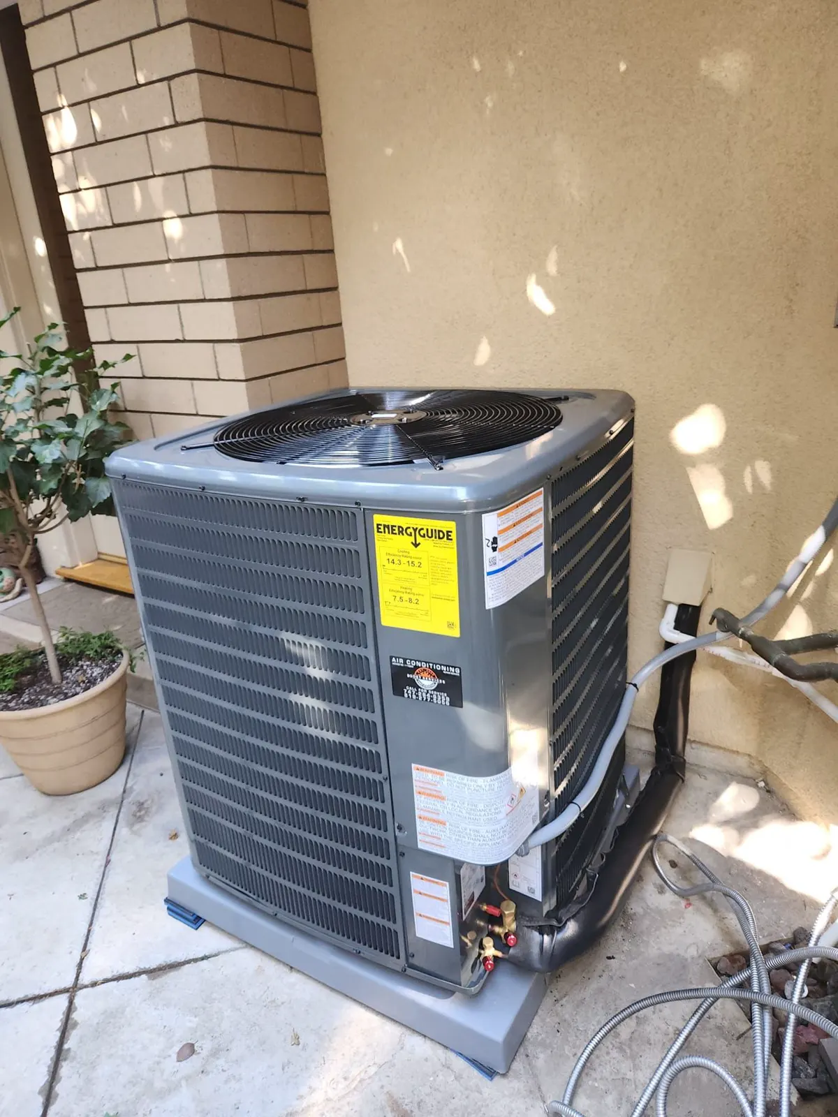 New condenser on a patio beside the house
