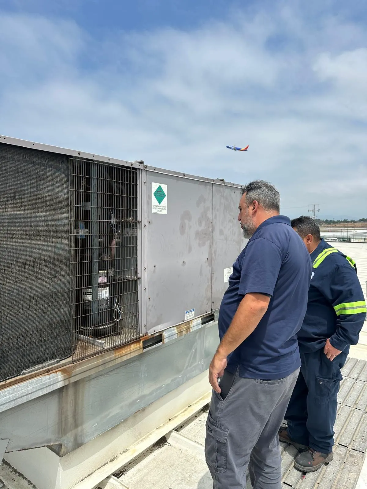 Technicians at a rooftop package unit