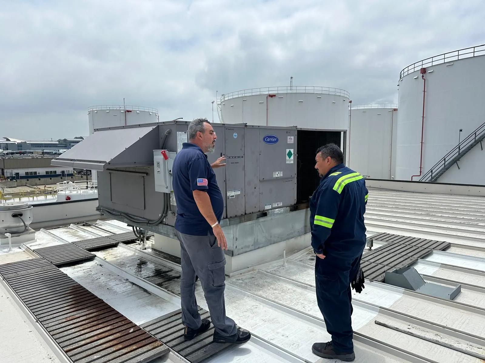 Two Boost technicians at a commercial rooftop unit