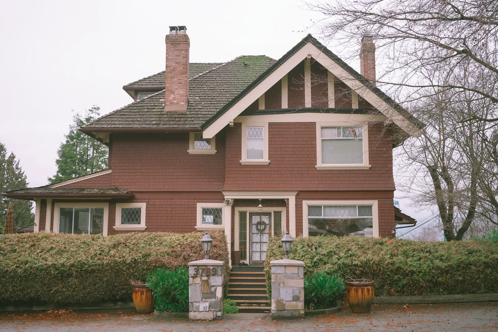 A brown house with a large front yard