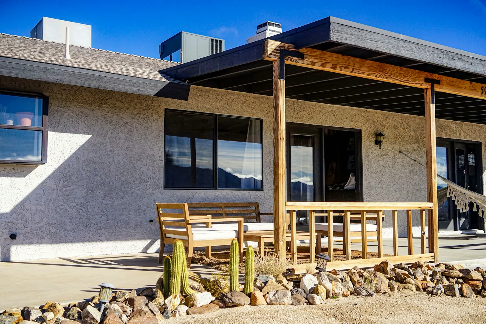 A house with a covered patio and a wooden bench