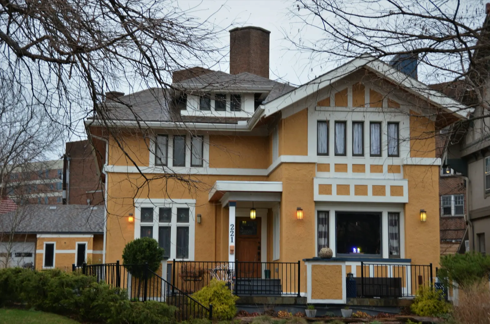 A yellow house with white trim and windows