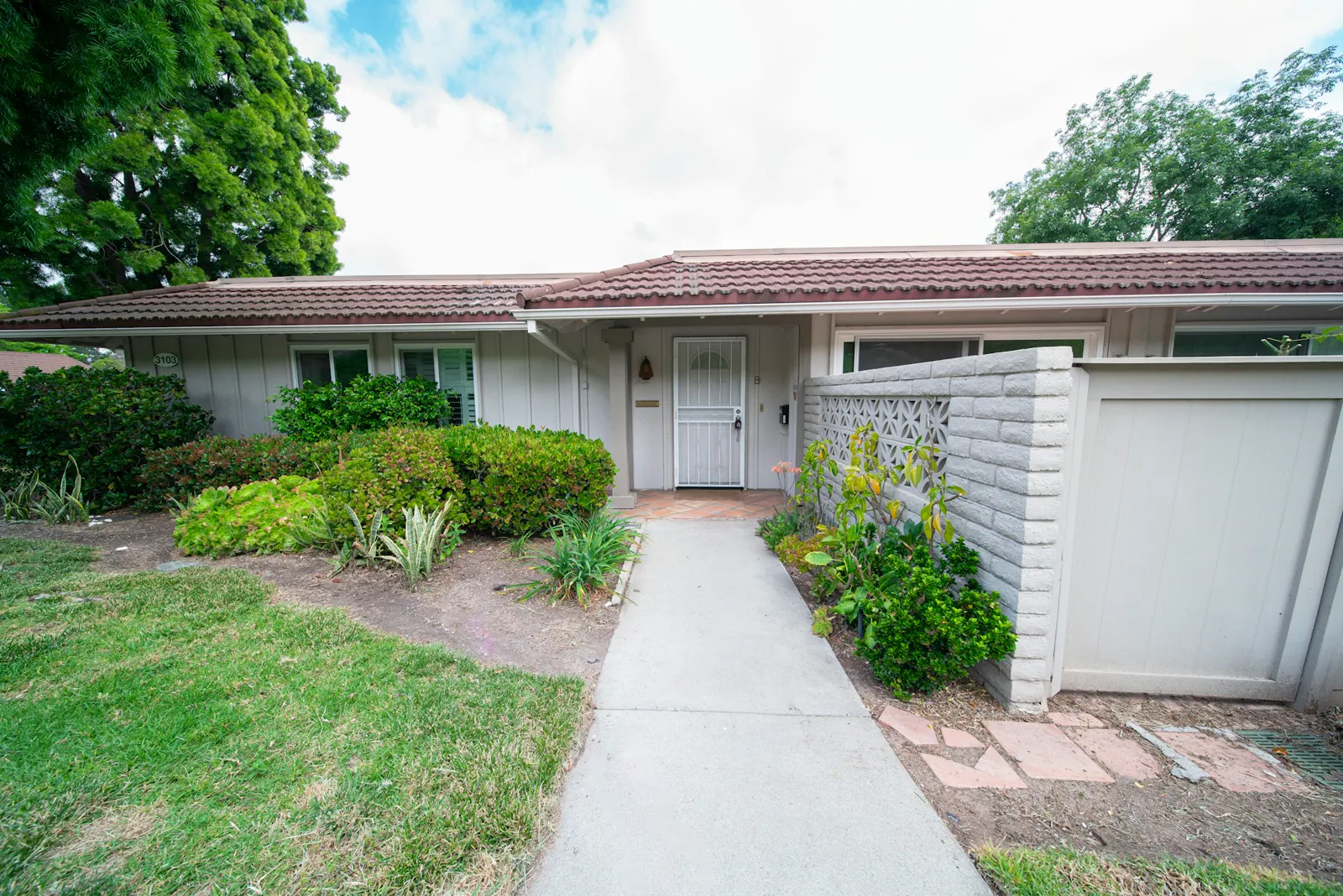 A house with a white door and a sidewalk in front of it