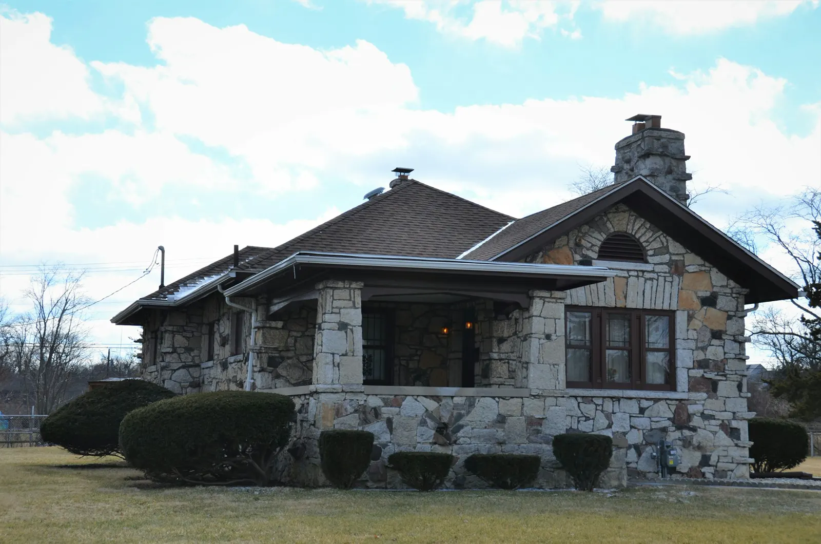 A stone house with a clock on the front of it