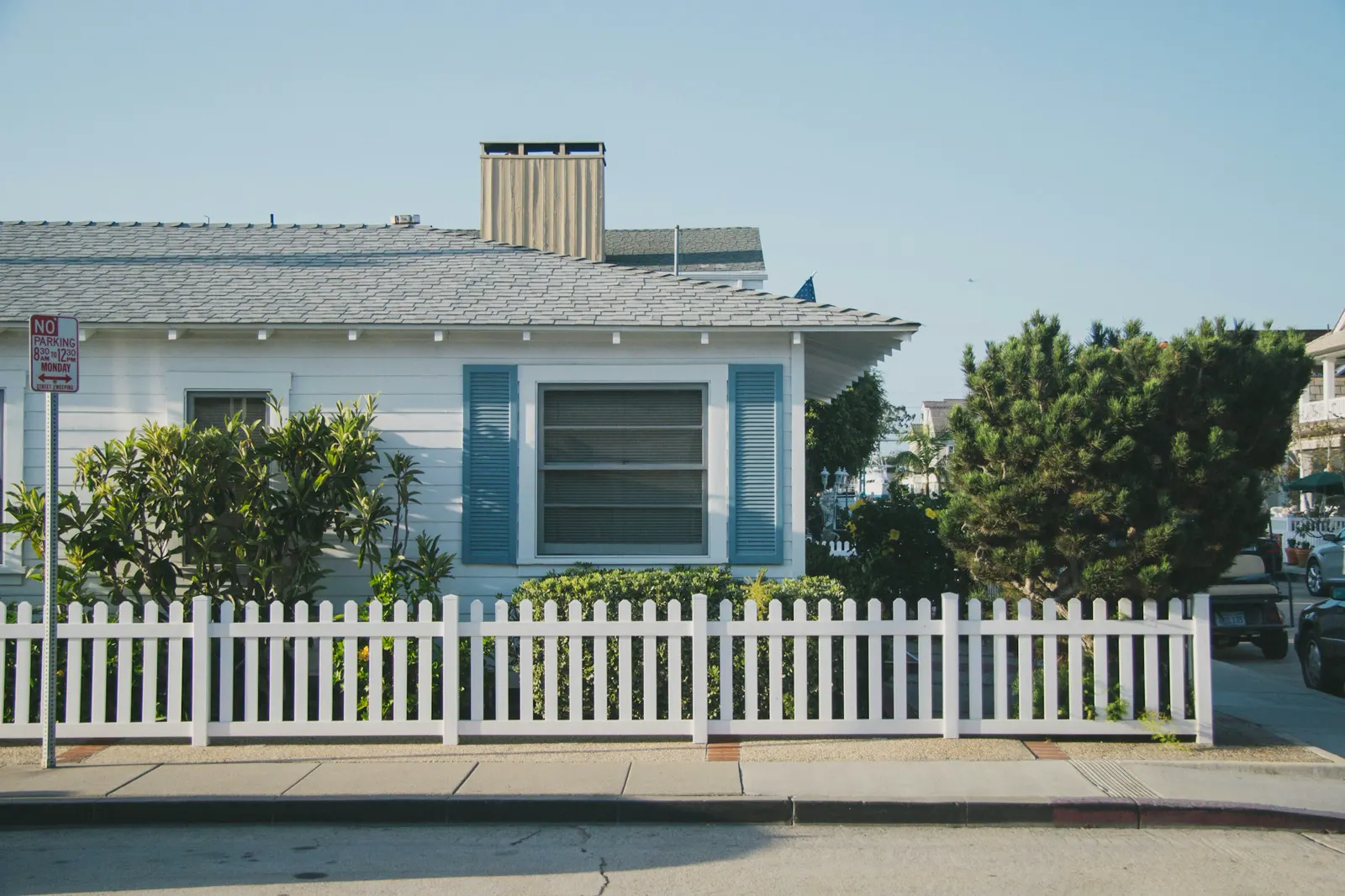 A cottage behind a white picket fence