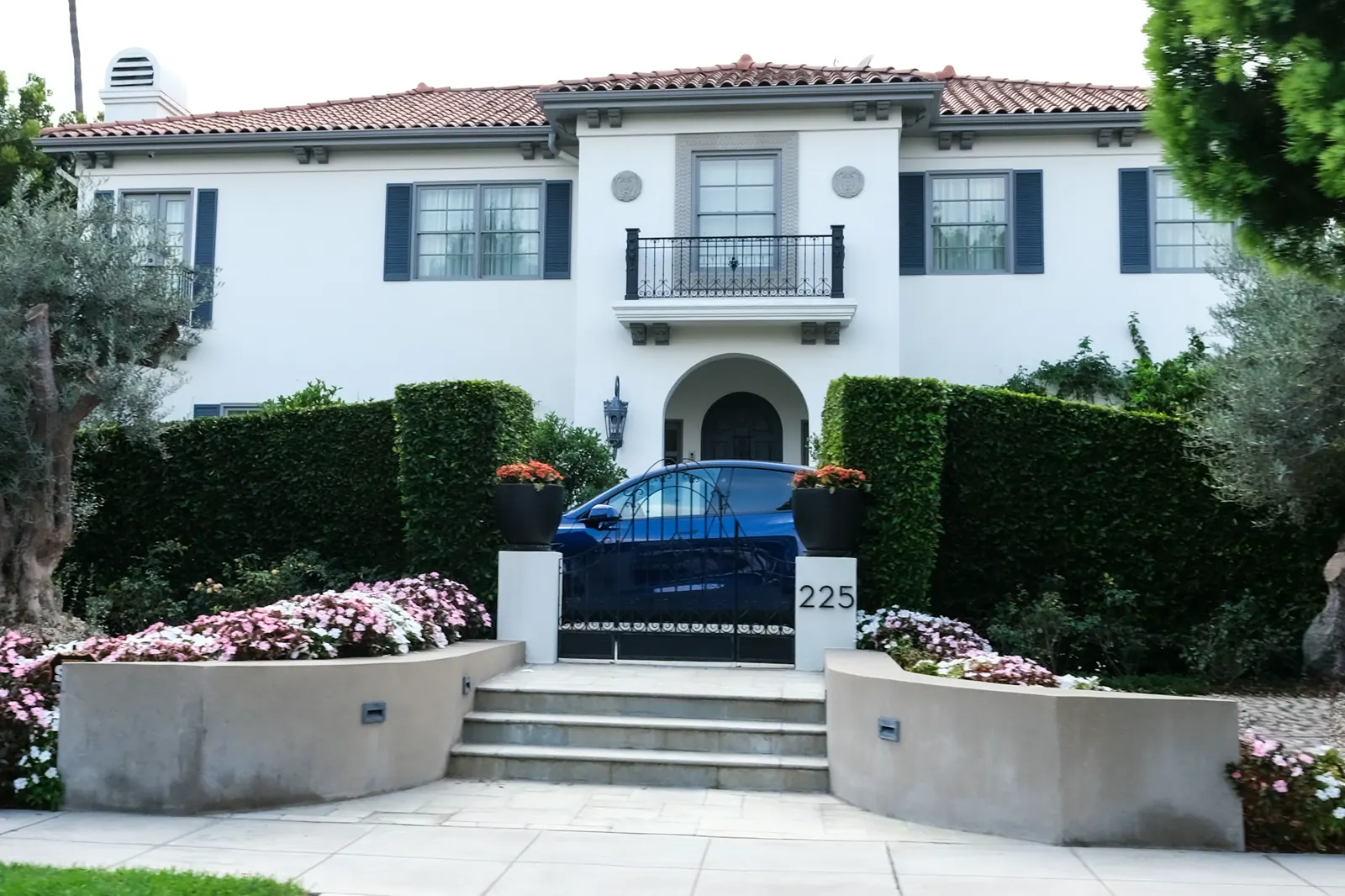 A Spanish-style home with clipped hedges