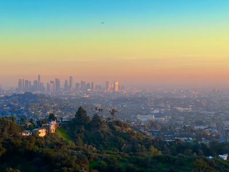Hillside homes with the Los Angeles skyline at dusk